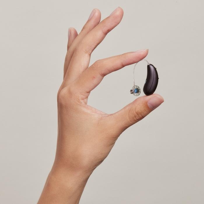 Hand holding Audicus Omni hearing aids
