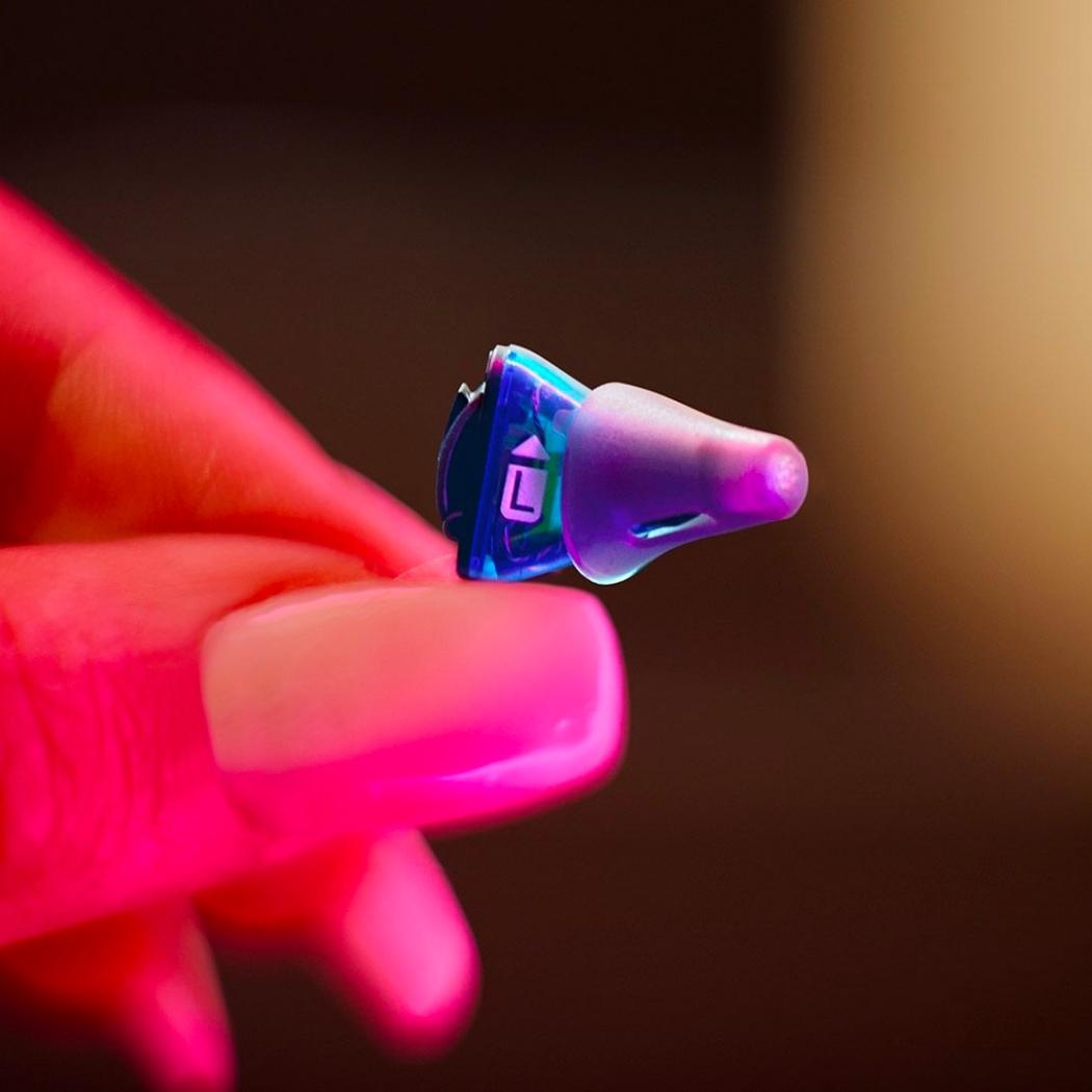 Tiny Signia Silk hearing aid in a woman's hand