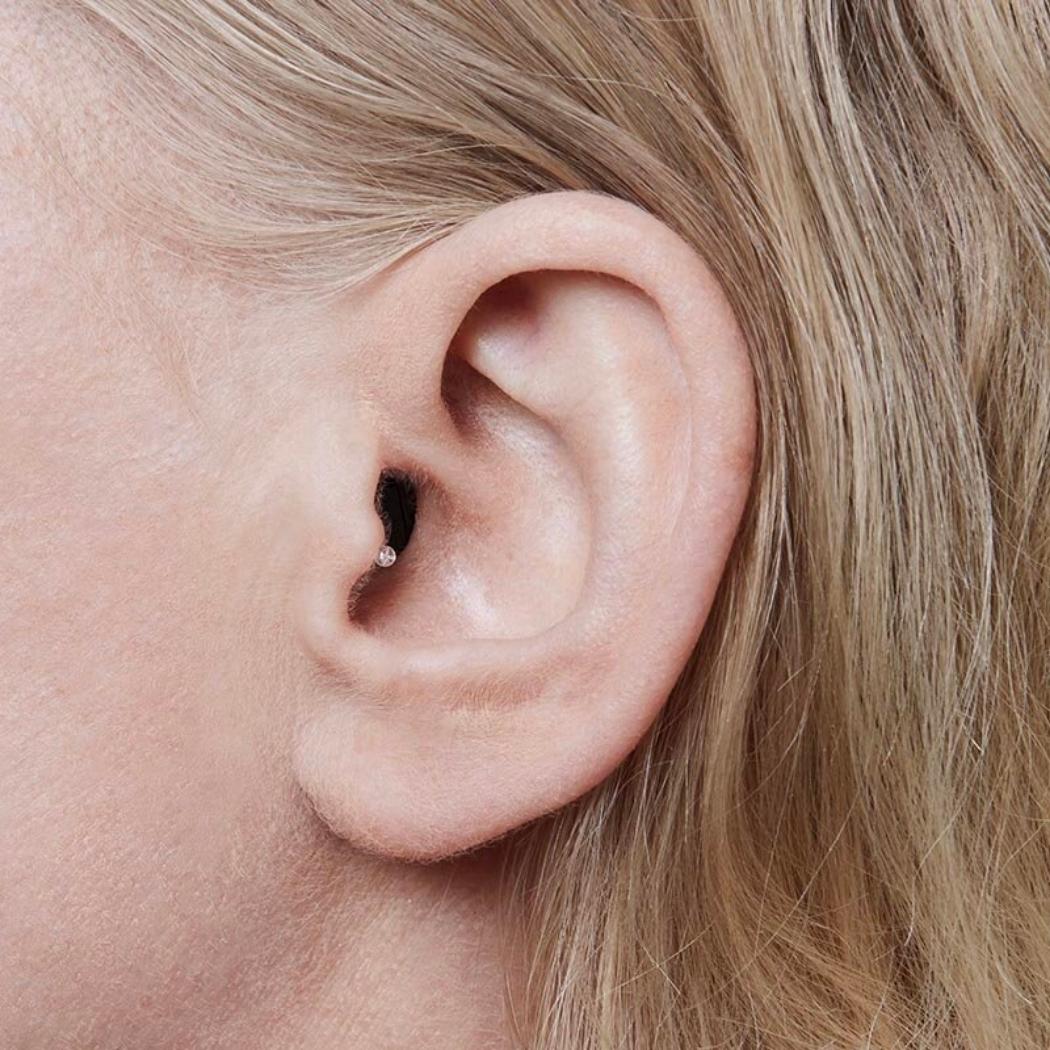 Image of woman's ear with invisible hearing aid inside