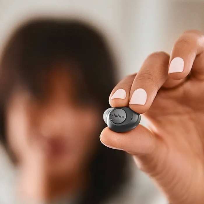 Woman holding a Jabra Enhance Plus with shallow depth of field.