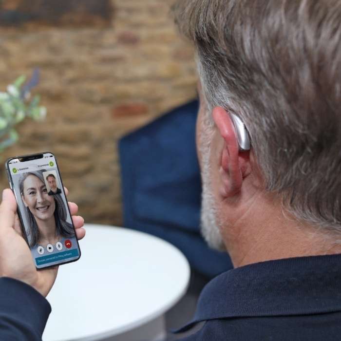 Man speaking to a digital assistant using his Phonak hearing aid